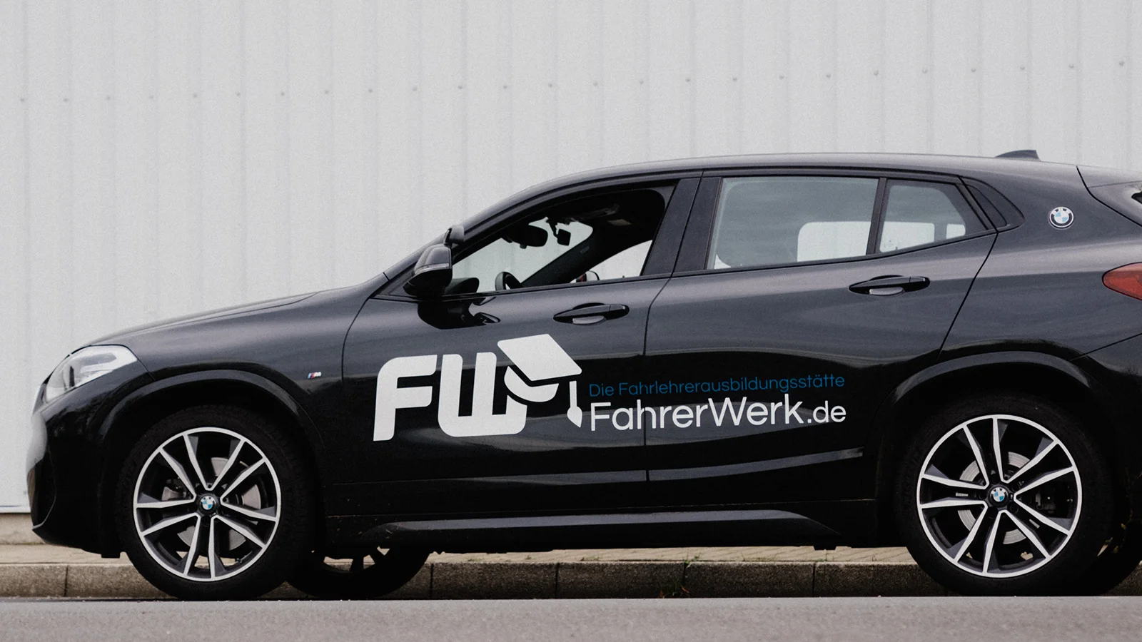 FahrerWerk BMW Schulungsfahrzeug mit FW-Logo und Schriftzug FahrerWerk.de